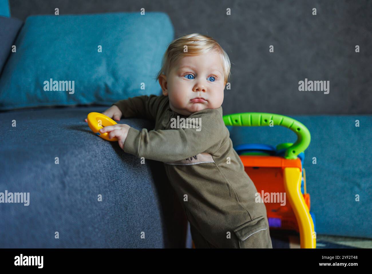 Erste Schritte des Babys. Glückliches Familienkind-Traumkonzept. Vater bringt der Tochter bei, dass sie vor dem Fenster erste Schritte im Lifestyle zu Hause macht. Vatertag Stockfoto