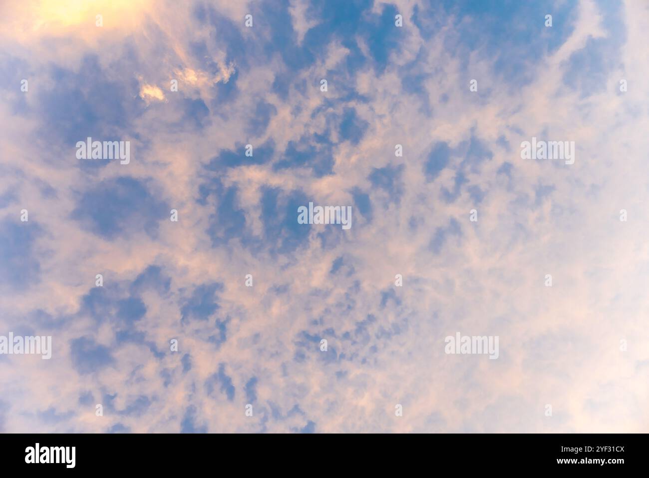 Altocumulus Wolken am blauen Himmel und Sonne bei Sonnenuntergang. Hintergrund. Stockfoto