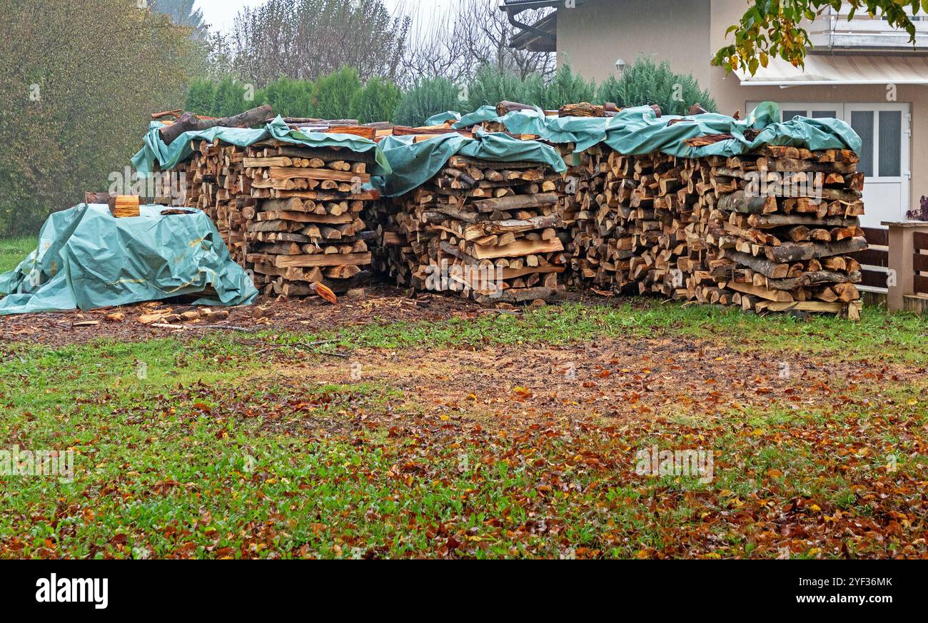 Frisch geschnittene Holzpfähle mit Kunststoffabdeckung im Garten draußen Stockfoto