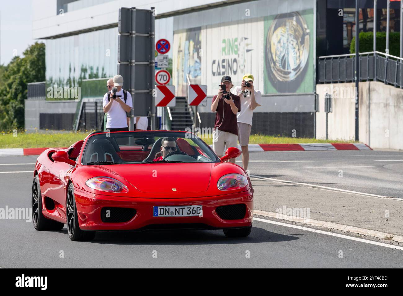 Nürburg, Deutschland - Blick auf einen roten Ferrari 360 Modena Spider, der auf einer Straße fährt. Stockfoto