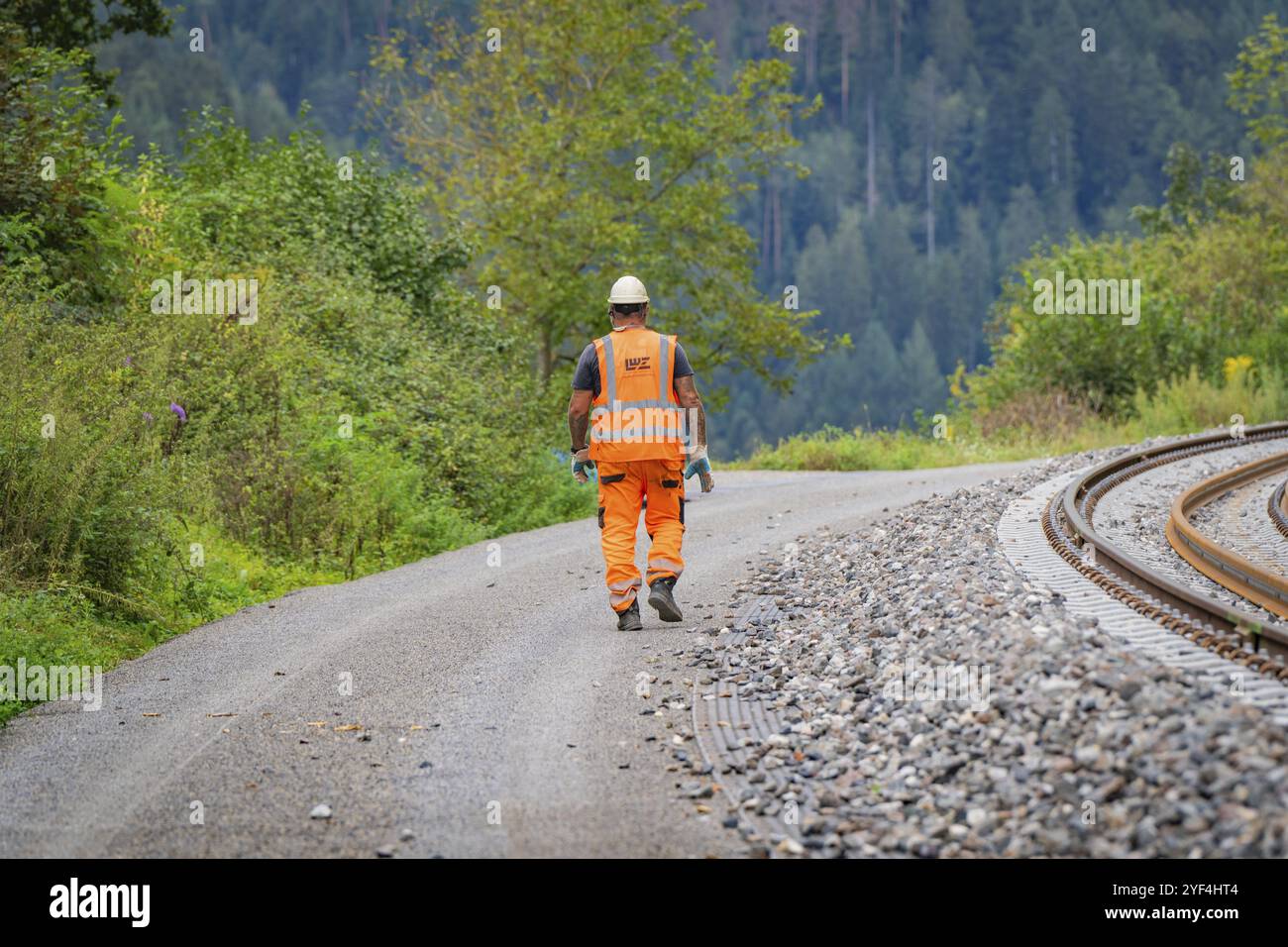 Bauarbeiter in orangener Schutzkleidung spaziert auf einem Schotterweg, Gleisbau, Hermann Hessebahn, Calw, Schwarzwald, Deutschland, Europ Stockfoto