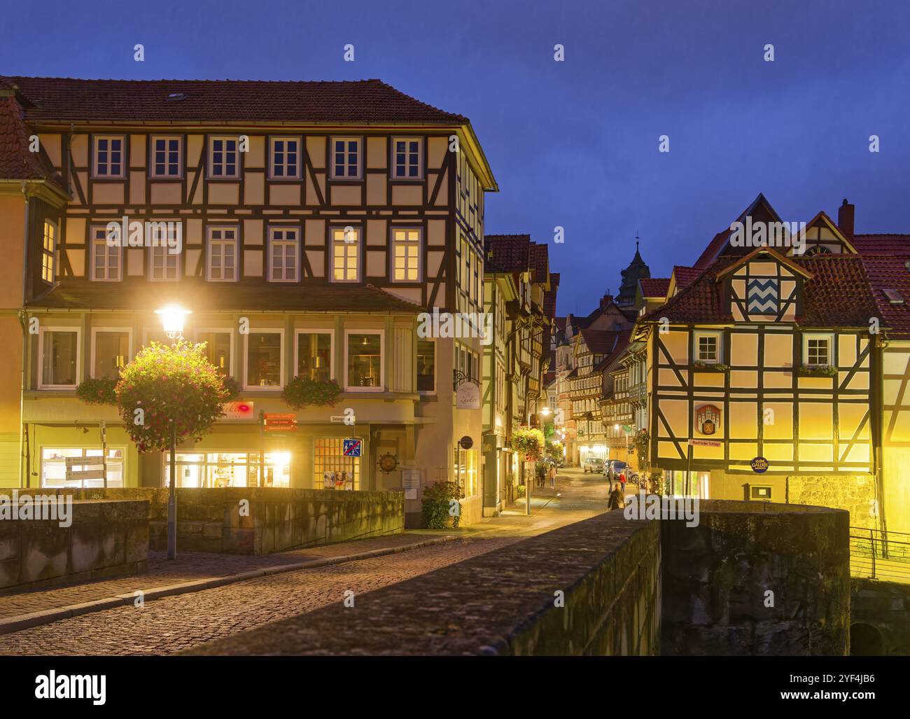 Die lange Straße in der Altstadt von Hannoversch Muenden mit Fachwerkhäusern am Abend. Die alte Werrabrücke im Vordergrund. Hann Stockfoto