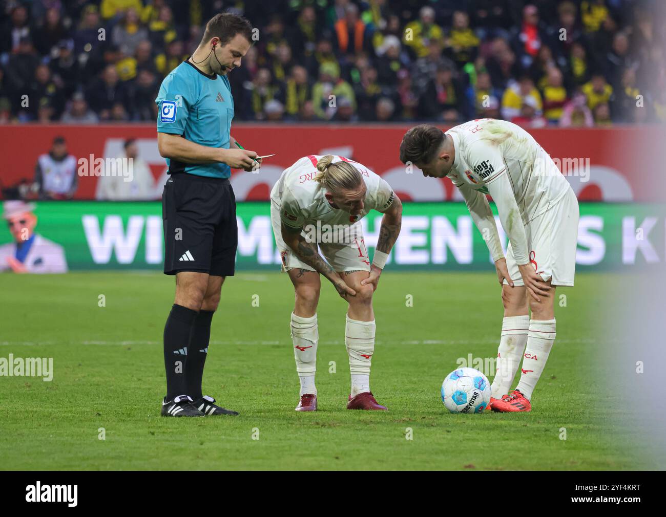 Verletzung Marius Wolf (FC Augsburg #11), mit Elvis Rexhbecaj (FC Augsburg #8), SR Wolfgang Haslberger; FC Augsburg gegen Borussia Dortmund, 8. SPIELTAG; DFL-VORSCHRIFTEN VERBIETEN DIE VERWENDUNG VON FOTOS ALS BILDSEQUENZEN UND/ODER QUASI-VIDEO. Stockfoto