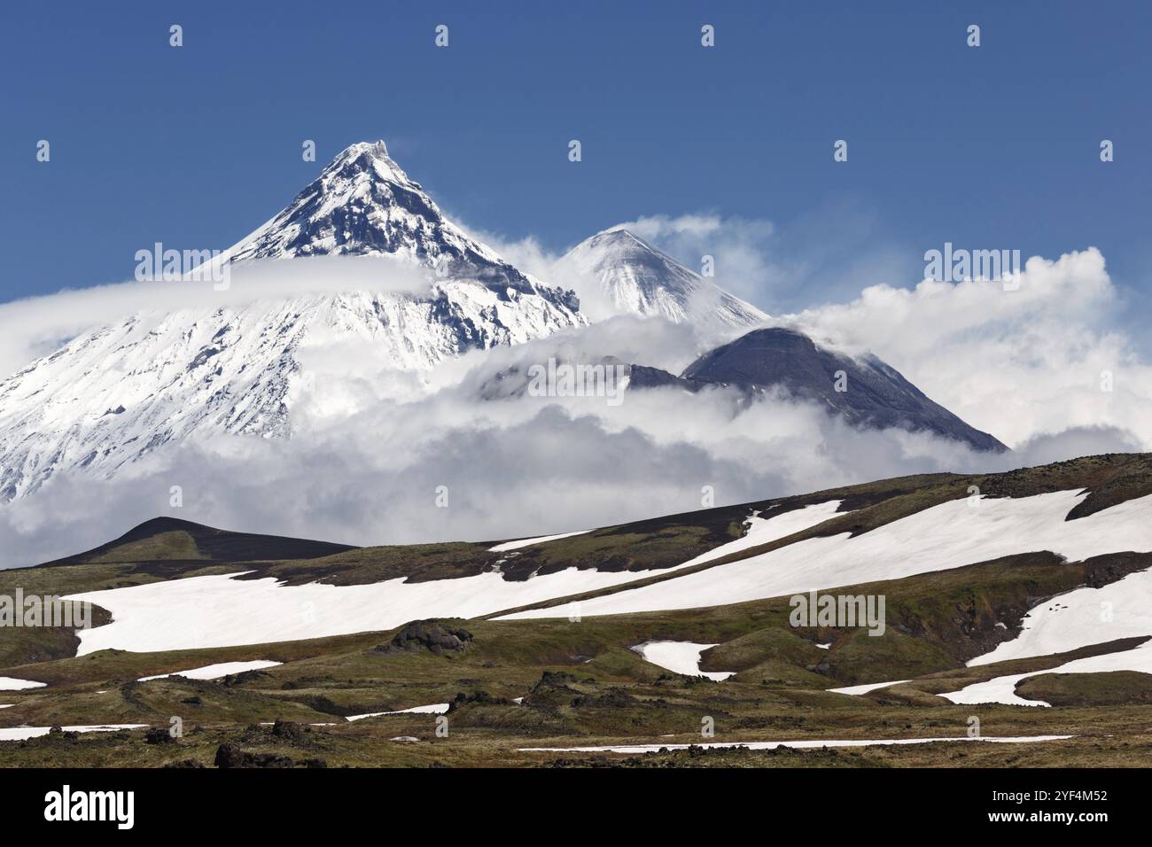 Wunderschöne Berglandschaft der Halbinsel Kamtschatka: Blick auf den Vulkan Kamen, den aktiven Vulkan Klyuchevskoy und den aktiven Vulkan Bezymianny an sonnigen Tagen. Ru Stockfoto