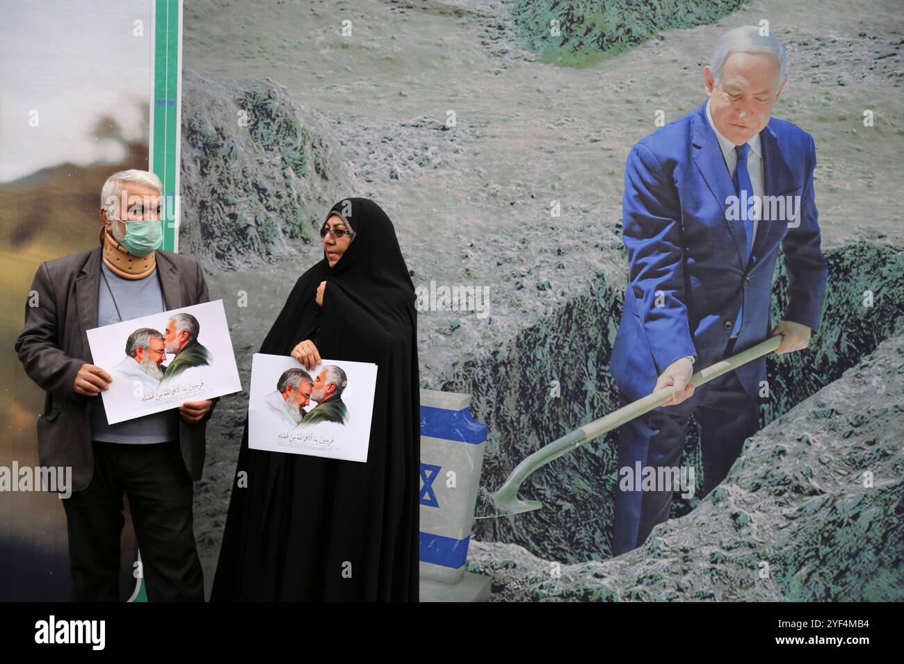 Teheran, Iran. November 2024. Ein älteres iranisches Ehepaar steht neben einem Plakat von Benjamin Netanjahu, dem israelischen Premierminister, während einer Anti-US-Kundgebung zum 45. Jahrestag der Übernahme durch die US-Botschaft vor dem ehemaligen Botschaftsgebäude in Teheran. Am 4. November 1979 übernahmen iranische Studenten die US-Botschaft in Teheran und hielten über 50 amerikanische Diplomaten und Wärter 444 Tage lang als Geiseln. Diese Aktion folgte der Entscheidung der USA, dem entlassenen Schah aus dem Iran die medizinische Behandlung in Amerika zu erlauben. Kürzlich, am 2. November, warnte der Oberste Führer Ayatollah Ali Khamenei vor einer ernsten Re Stockfoto