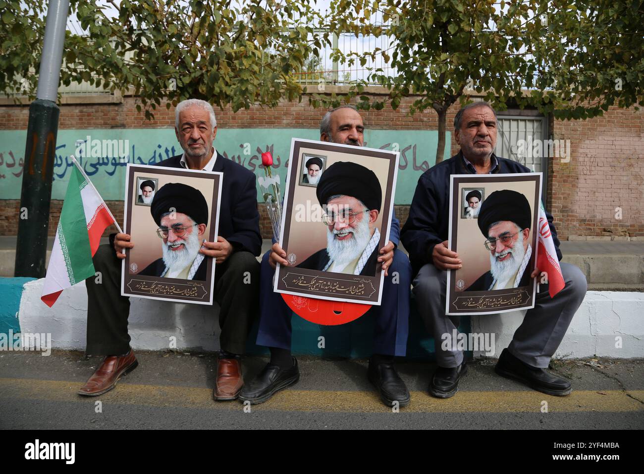 Teheran, Iran. November 2024. Drei ältere iranische Männer halten Plakate des iranischen Obersten Führers Ayatollah Ali Khamenei während einer Anti-US-Kundgebung zum 45. Jahrestag der Übernahme durch die US-Botschaft vor dem ehemaligen Botschaftsgebäude in Teheran. Am 4. November 1979 übernahmen iranische Studenten die US-Botschaft in Teheran und hielten über 50 amerikanische Diplomaten und Wärter 444 Tage lang als Geiseln. Diese Aktion folgte der Entscheidung der USA, dem entlassenen Schah aus dem Iran die medizinische Behandlung in Amerika zu erlauben. Vor kurzem, am 2. November, warnte der Oberste Führer Ayatollah Ali Chamenei vor einer ernsten Reaktion auf die U Stockfoto