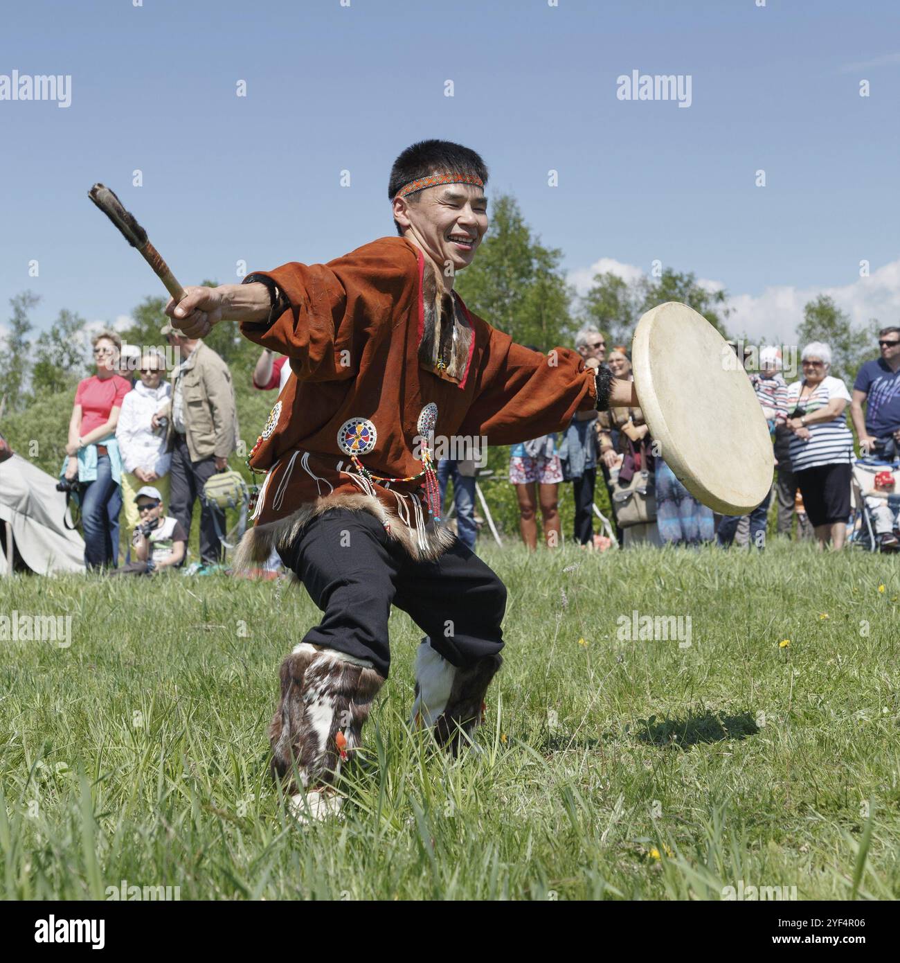 ELIZOVO STADT, KAMTSCHATKA HALBINSEL, RUSSLAND, 15. JUNI 2013: Mann in Kleidung Ureinwohner von Kamtschatka tanzen mit einem Tamburin. Feier des Tages Stockfoto