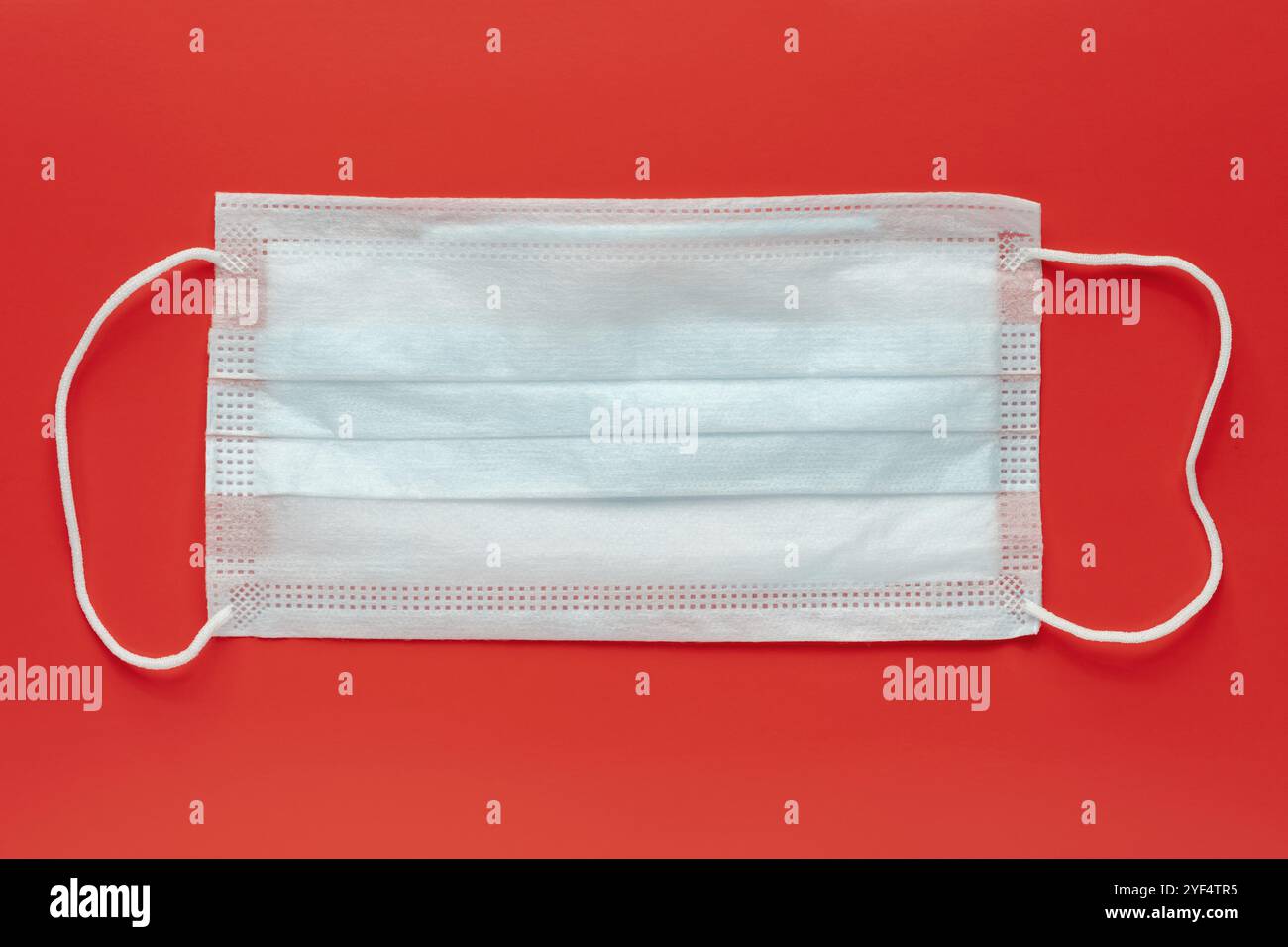 Medizinisch-chirurgische Gesichtsmaske auf rotem Hintergrund. Weltpandemieversicherung, Flugkrankheiten, SARS, Influenza. Anti-Virus-Schutzmasken für Menschen, Cove Stockfoto