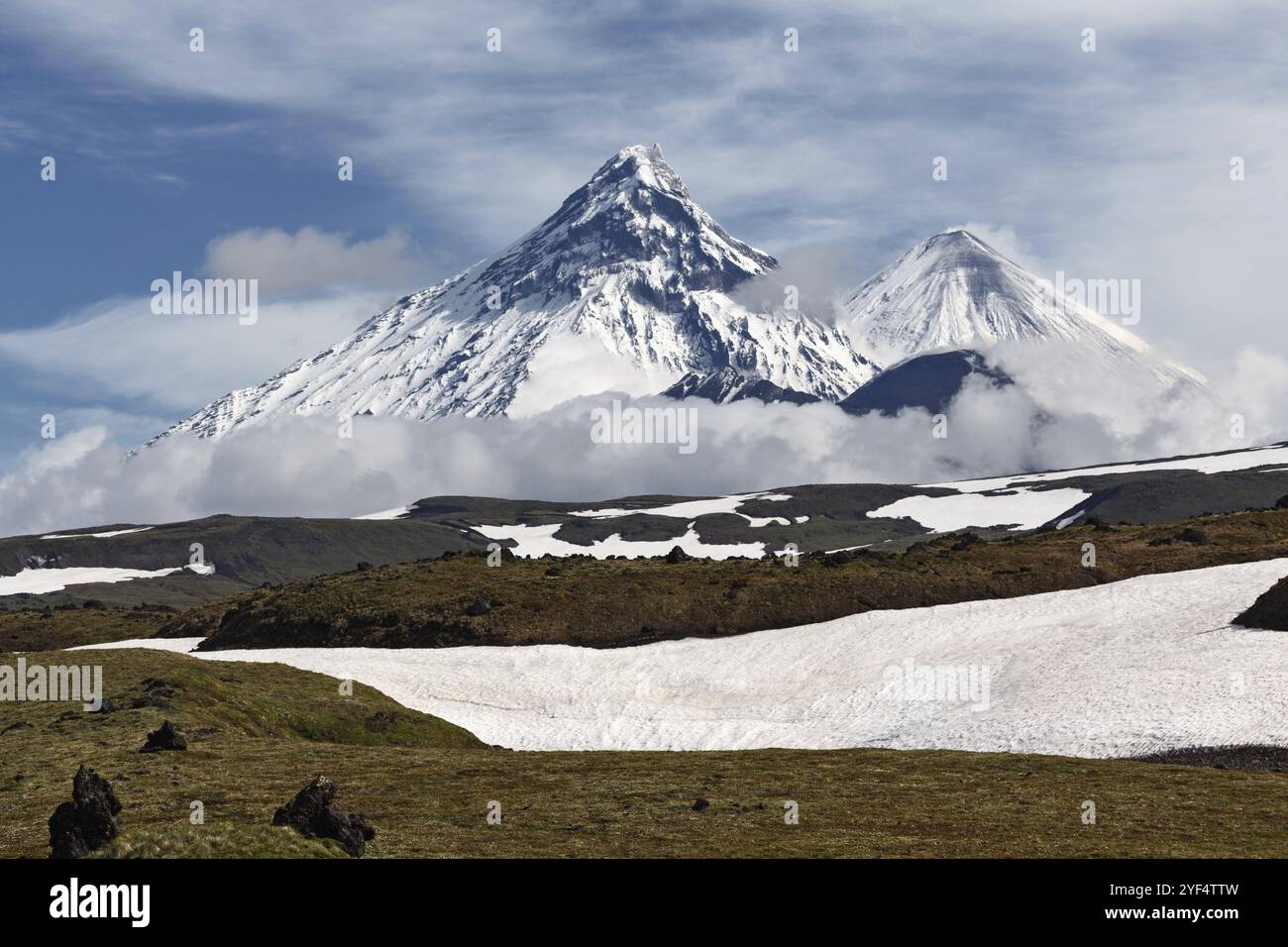 Wunderschöne Berglandschaft der Halbinsel Kamtschatka: Blick auf den Vulkan Kamen, den aktiven Vulkan Klyuchevskoy und den aktiven Vulkan Bezymianny an einem sonnigen Tag. Stockfoto