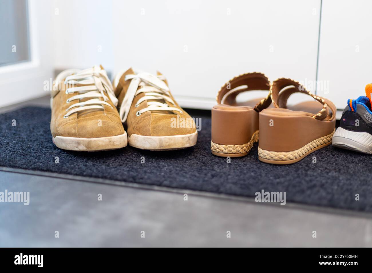 Schuhfamilie, Vater, Mutter und Kinderschuh. Sneaker, Braune Sandalen, Kinder Sneaker. Hochwertige Fotos Stockfoto