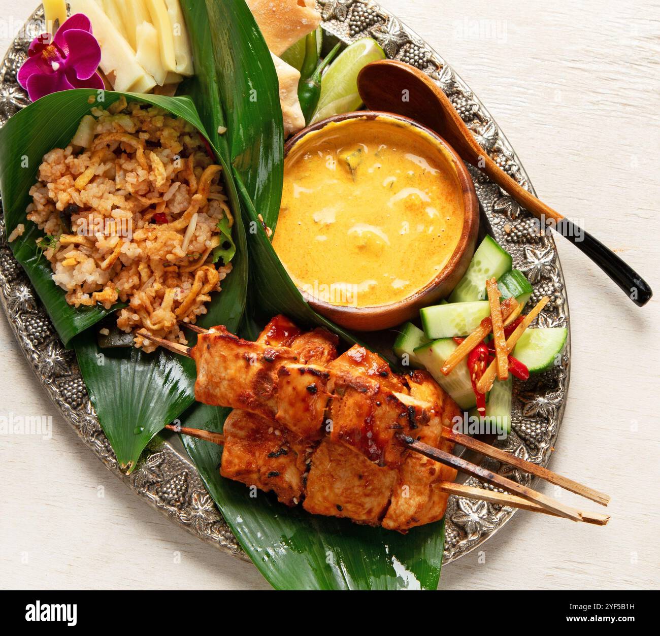 Ein traditioneller indonesischer Hühnersatay, serviert mit gedämpftem Reis und Sauce auf hellem Hintergrund. Draufsicht. Stockfoto