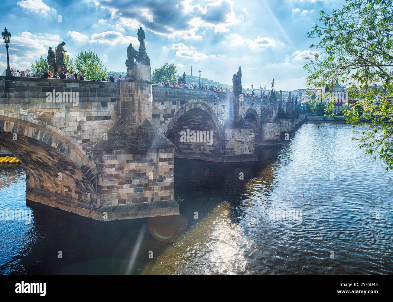 PRAG - 10. MAI 2024: Touristen wandern auf der Karlsbrücke in Prag mit Prager Burg und Moldau im Hintergrund an sonnigen Sommertagen Stockfoto PRAG - 10. MAI 2024: Touristen wandern auf der Karlsbrücke in Prag mit Prager Burg und Moldau im Hintergrund an sonnigen Sommertagen Stockfoto