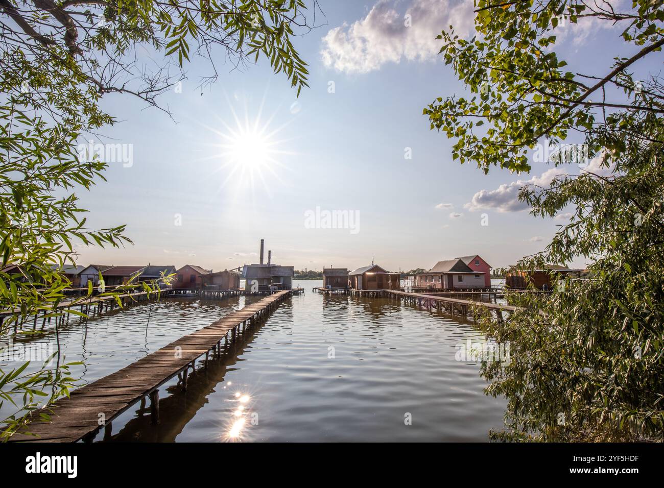 Holzhäuser im Wasser bei Sonnenuntergang. Lange Holzwege des schwimmenden Dorfes Bokodi am Balaton, Ungarn Stockfoto