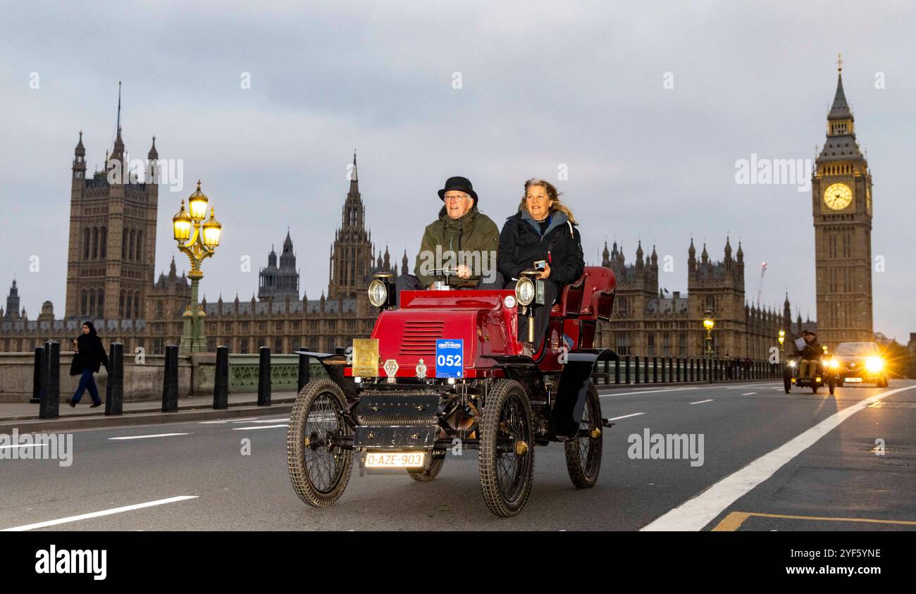 London, Großbritannien. November 2024. Die ersten Veteranenautos überqueren die Westminster Bridge. RM Sotheby's London to Brighton Veteran Car Run 2024, organisiert vom Royal Automobile Club und es ist 120-jähriges Jubiläum des Ladies' Automobile Club - rund 350 Veteranenautos mit vielen Fahrern in historischen Kostümen machen die 60 km lange Reise. Die Fahrzeuge sind meist benzinbetriebene Fahrzeuge, aber einige davon werden mit Dampf angetrieben und einige sehr frühe Elektrofahrzeuge – alle wurden vor 1905 gebaut Stockfoto