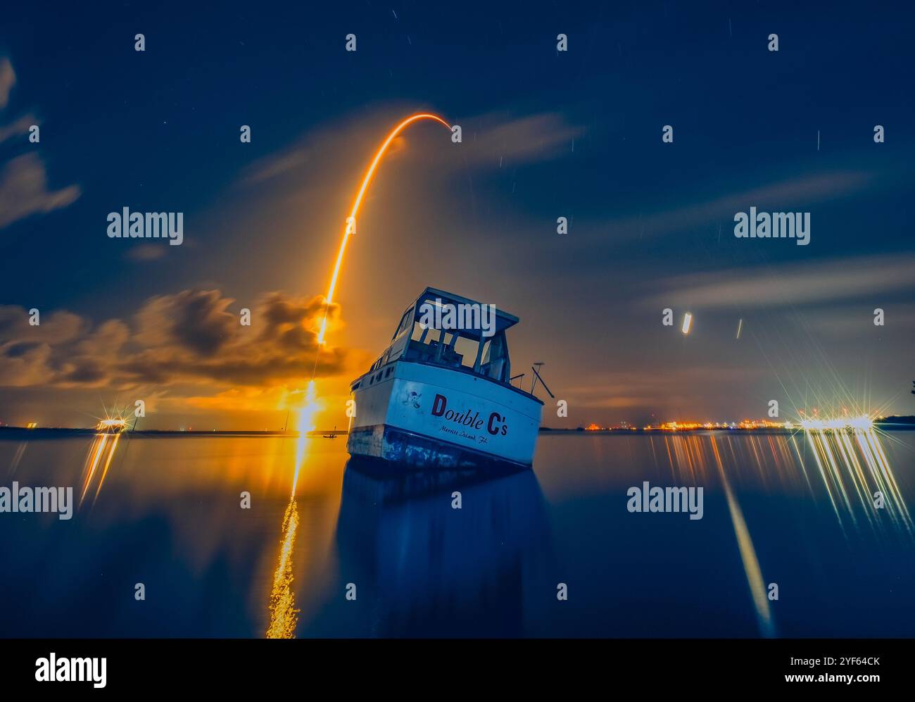 Ein Falcon 9 steigt im Juli 2024 hinter einem Boot auf dem Banana River in Florida in den Weltraum auf. Stockfoto