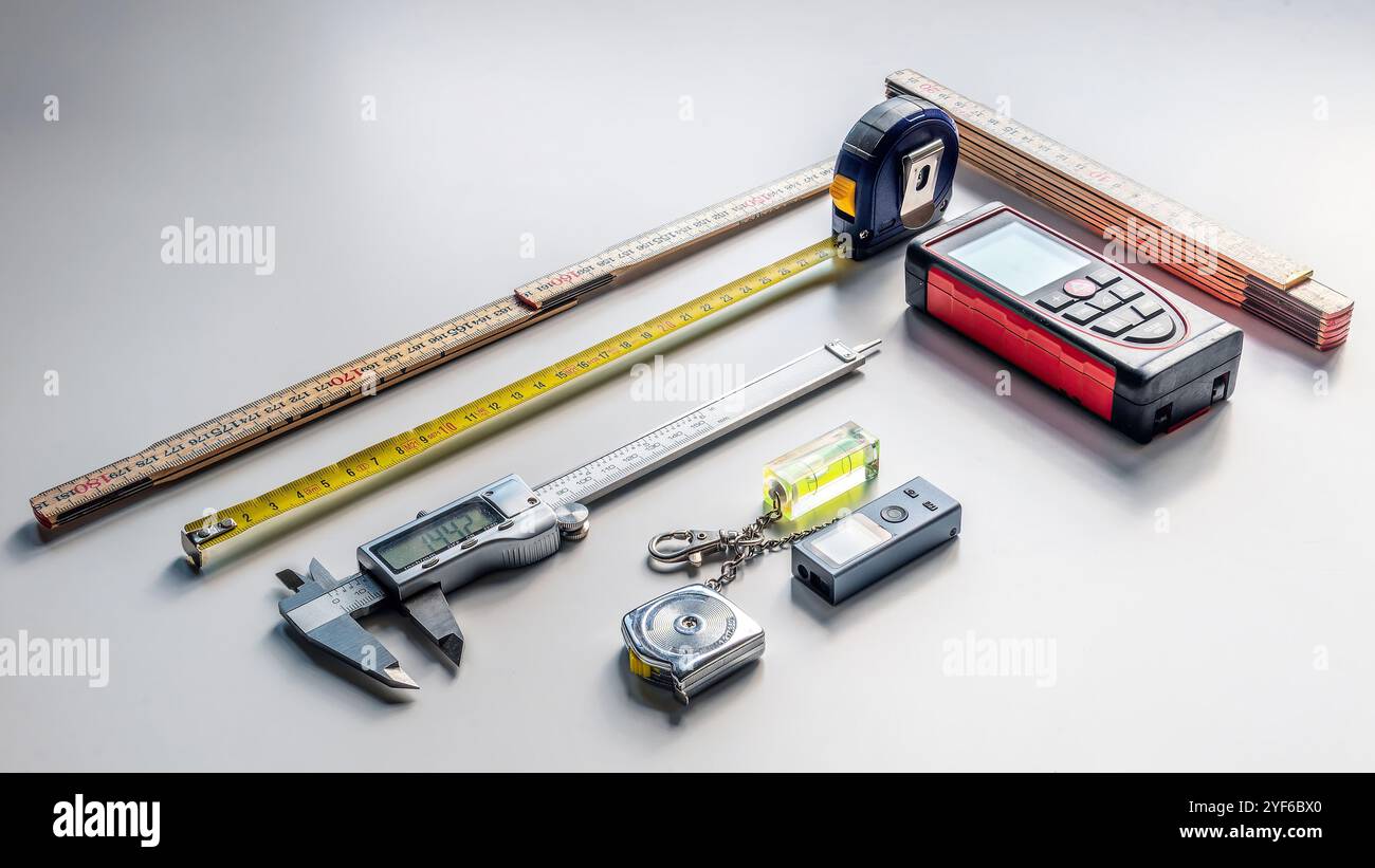 Auswahl an Messwerkzeugen (Laser-Entfernungsmesser, Bandmaß, Falzlineal, Ebene, Mini-Entfernungsmesser, Bremssattel) Stockfoto