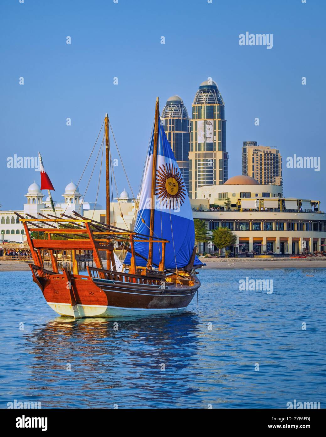 Dieses Foto zeigt eine traditionelle katarische Dau mit argentinischer Flagge, die während der FIFA-Weltmeisterschaft Katars vor der Corniche-Fanzone segelt Stockfoto