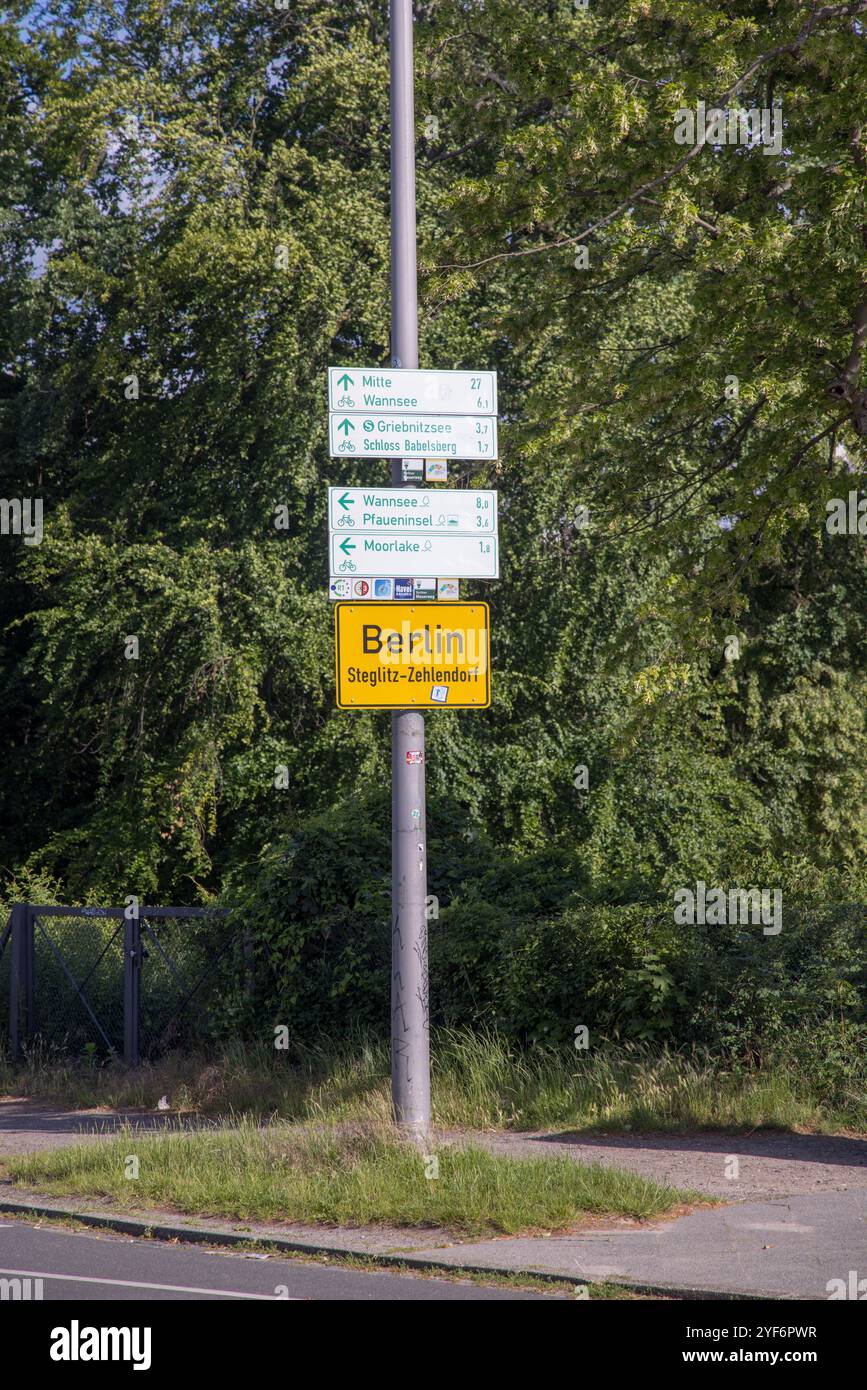 Gelbes Stadtschild Berlin Steglitz-Zehlendorf und weiße Radverkehrsschilder in der Nähe der Glienicker Brücke Stockfoto