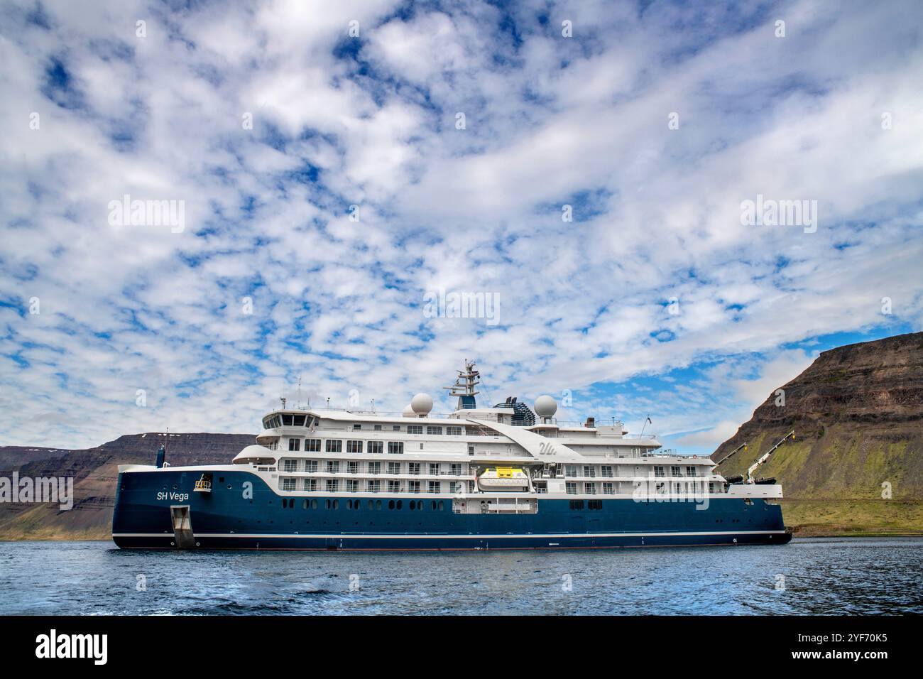 Die SH Vega Cruise ist ein Expeditionsschiff, das von Swan Hellenic betrieben wird, in der Nähe des Dynjandi Wasserfalls an den Westfjorden Islands. SH Vega ist unsere Marke Stockfoto