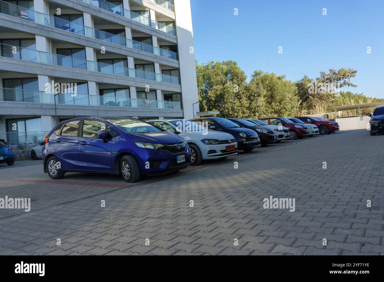 Gaziveren Cyprus -20.10.2024 mehrere Autos parken ordentlich auf einem gut organisierten Grundstück neben einem modernen Gebäude an einem klaren Tag. Stockfoto