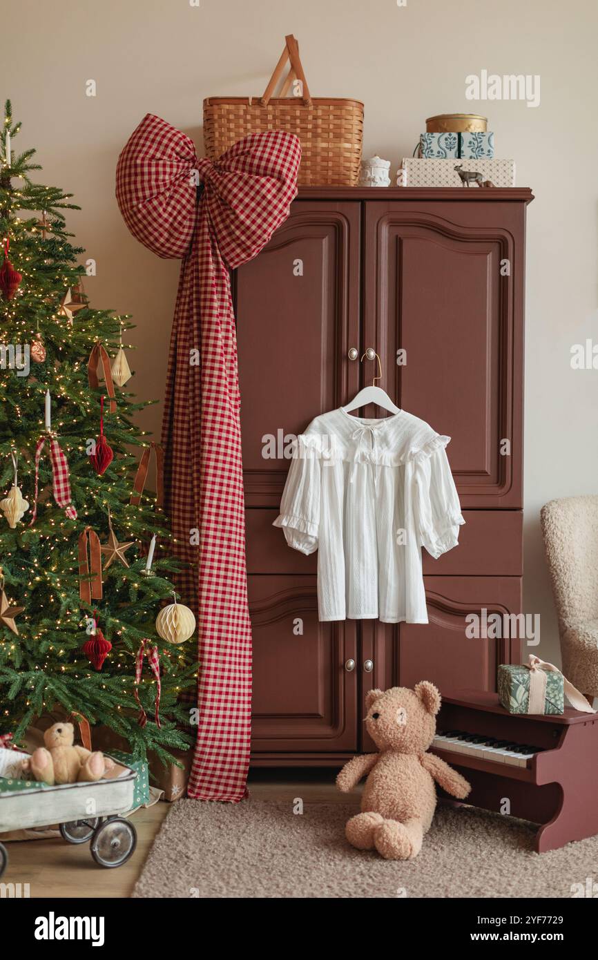Die Bluse hängt an einer Schranktür in einem festlichen Schlafzimmer mit einem Weihnachtsbaum und Dekorationen Stockfoto