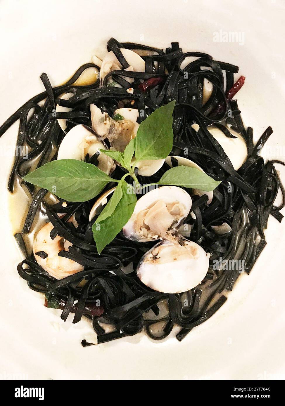Blick von oben auf einen Teller mit Tintenfisch-Linguine-Nudeln mit Muscheln und Nudeln Stockfoto