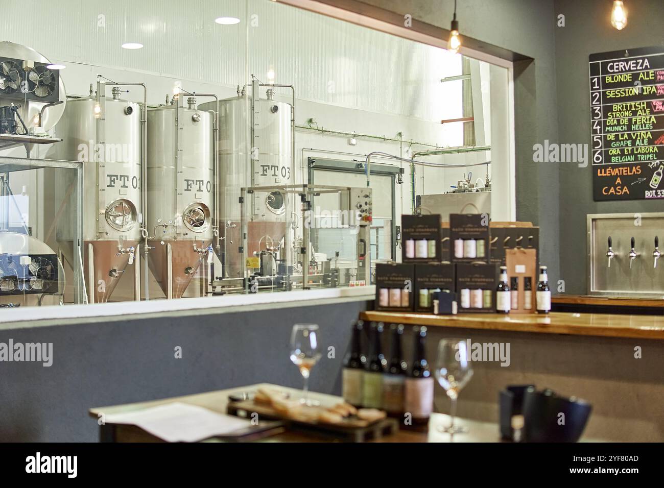 Kleiner Bierladen und Fabrikinnenraum. Kleines Unternehmen mit Sichtfenster zum Industriegebiet der Alkoholherstellung Stockfoto