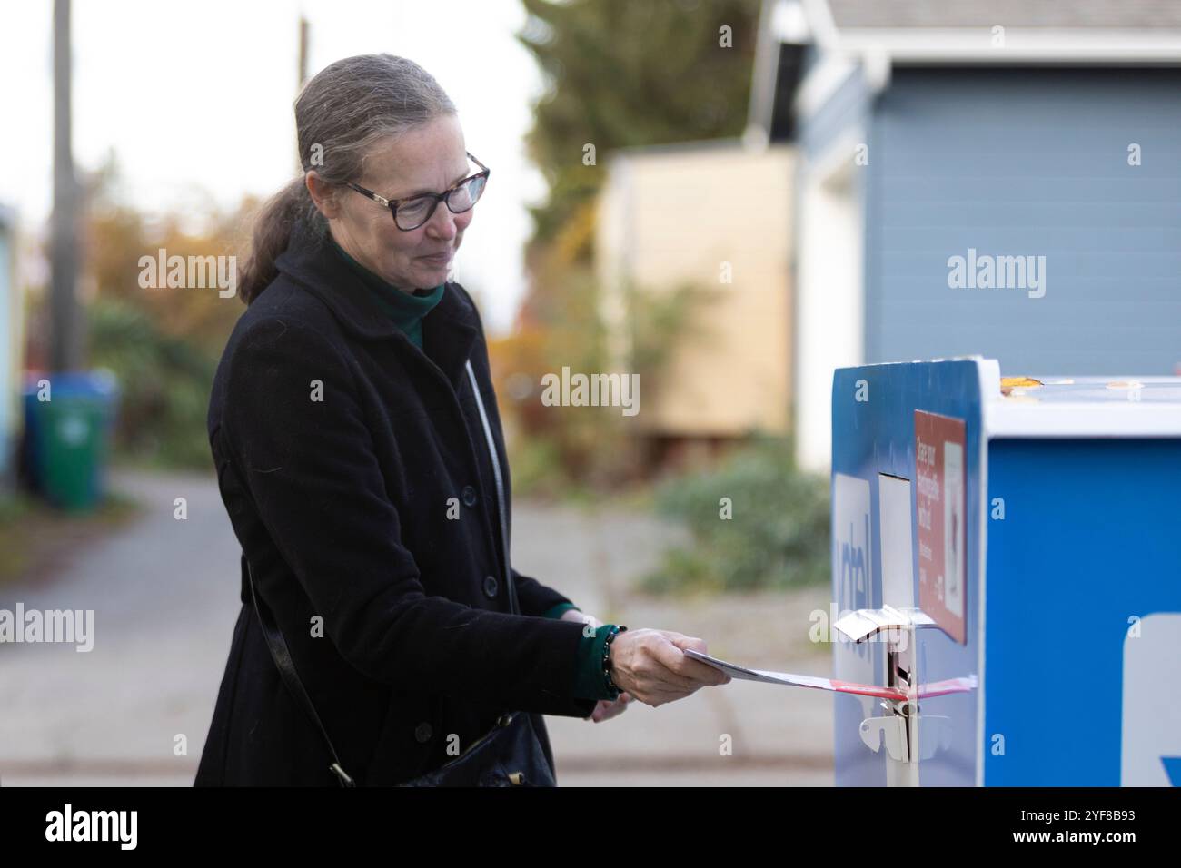 Seattle, Washington, USA. November 2024. Eine Wählerin gibt ihre Stimme an einer Wahlurne in Seattles High Point-Viertel ab. Quelle: Paul Christian Gordon/Alamy Live News Stockfoto