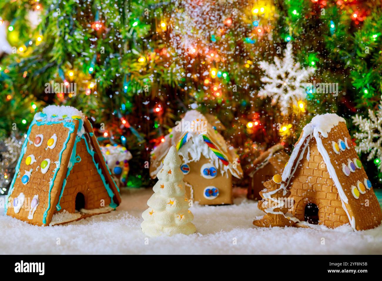 Weihnachtsbaum und farbenfrohe Girlanden schmücken das Lebkuchenhaus. Stockfoto