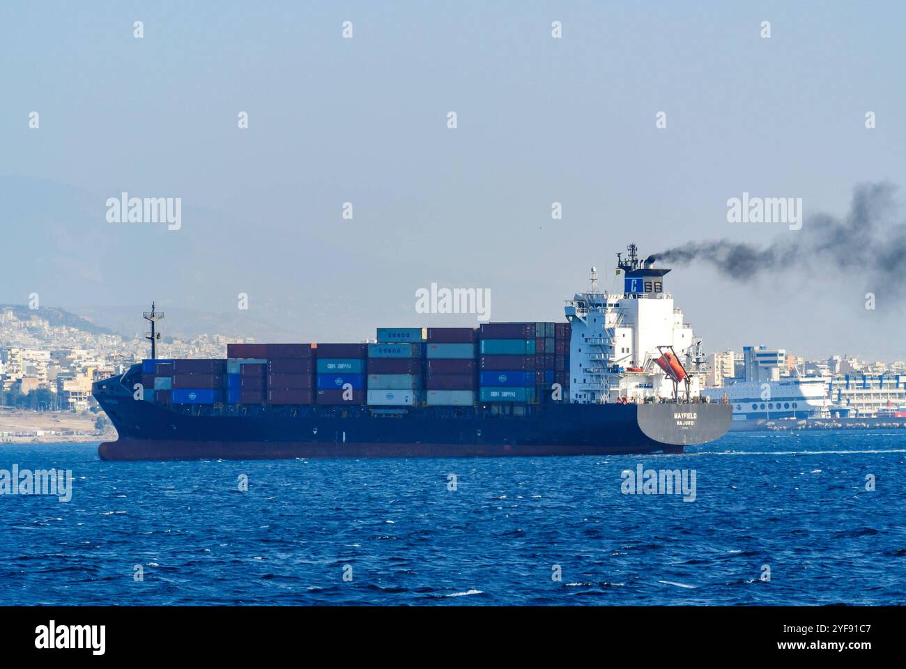 piräus, griechenland, 30 okt 2024, Containerschiff mayfield im Hafen von piräus, griechenland mit schwarzem Rauch, Verschmutzung *** piräus, griechenland, 30 okt 2024, Containerschiff mayfield im hafen von piräus, griechenland mit schwarzem rauch, Umweltverschmutzung Copyright: xx Stockfoto