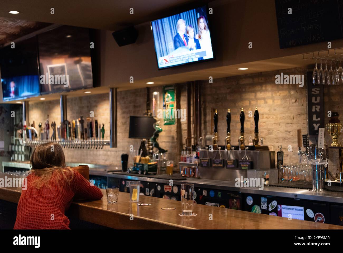 Ein Schirmherr in einer Bar in Chicago, Illinois, sieht, wie die Ergebnisse der US-Präsidentschaftswahlen 2016 im Fernsehen bekannt gegeben werden. Stockfoto