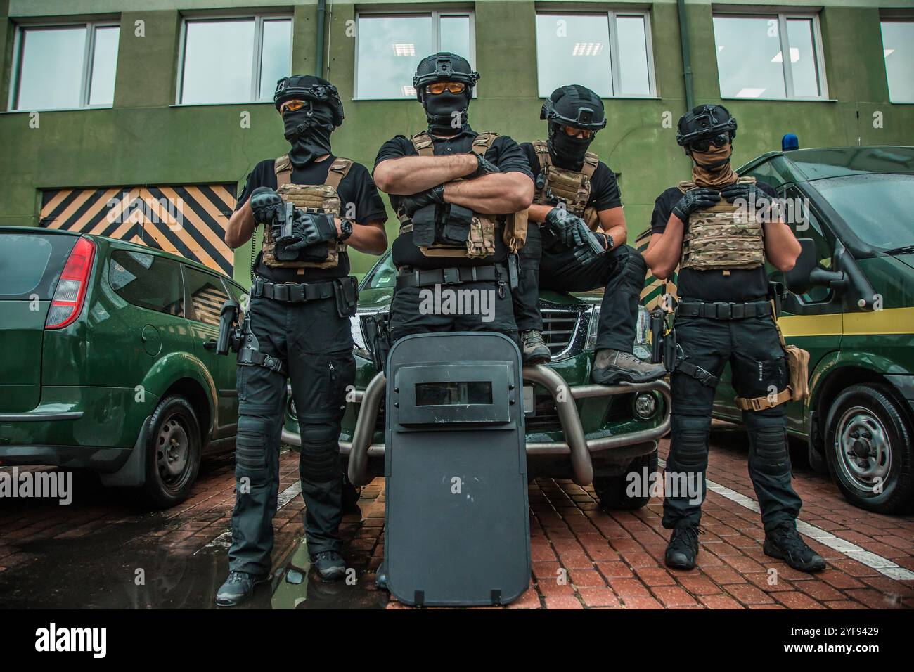 Elite taktische Einheit einsatzbereit, komplett ausgestattete Spezialeinsatzoffiziere mit moderner Ausrüstung vor städtischem Hintergrund Stockfoto