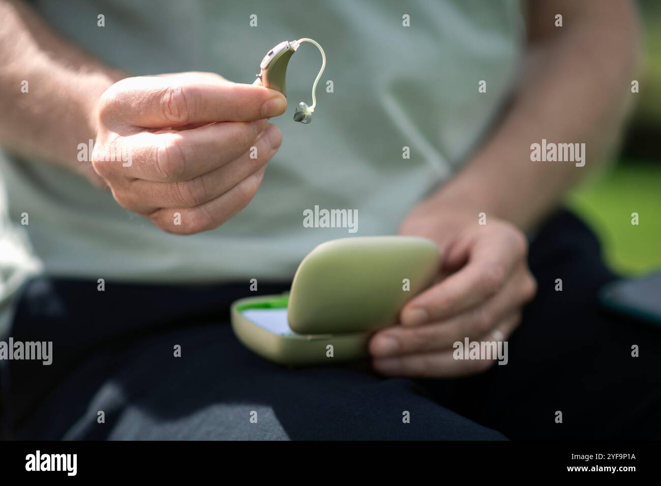 Nahaufnahme eines Menschen, der ein Hörgerät hält Stockfoto