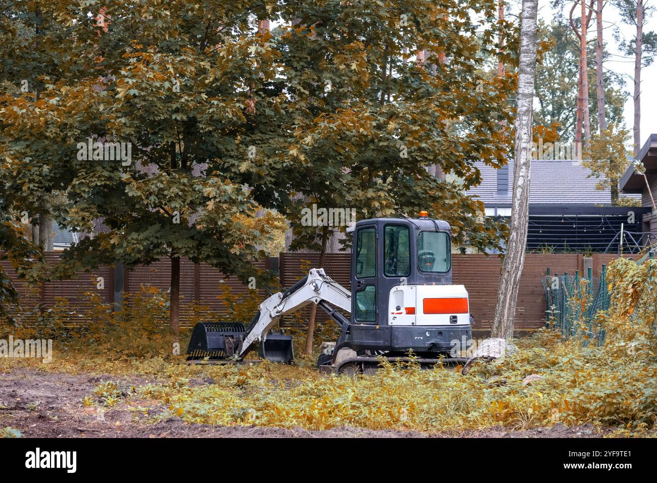 Kleiner Ladertraktor mit Raupenketten, die auf der Baustelle arbeiten Stockfoto
