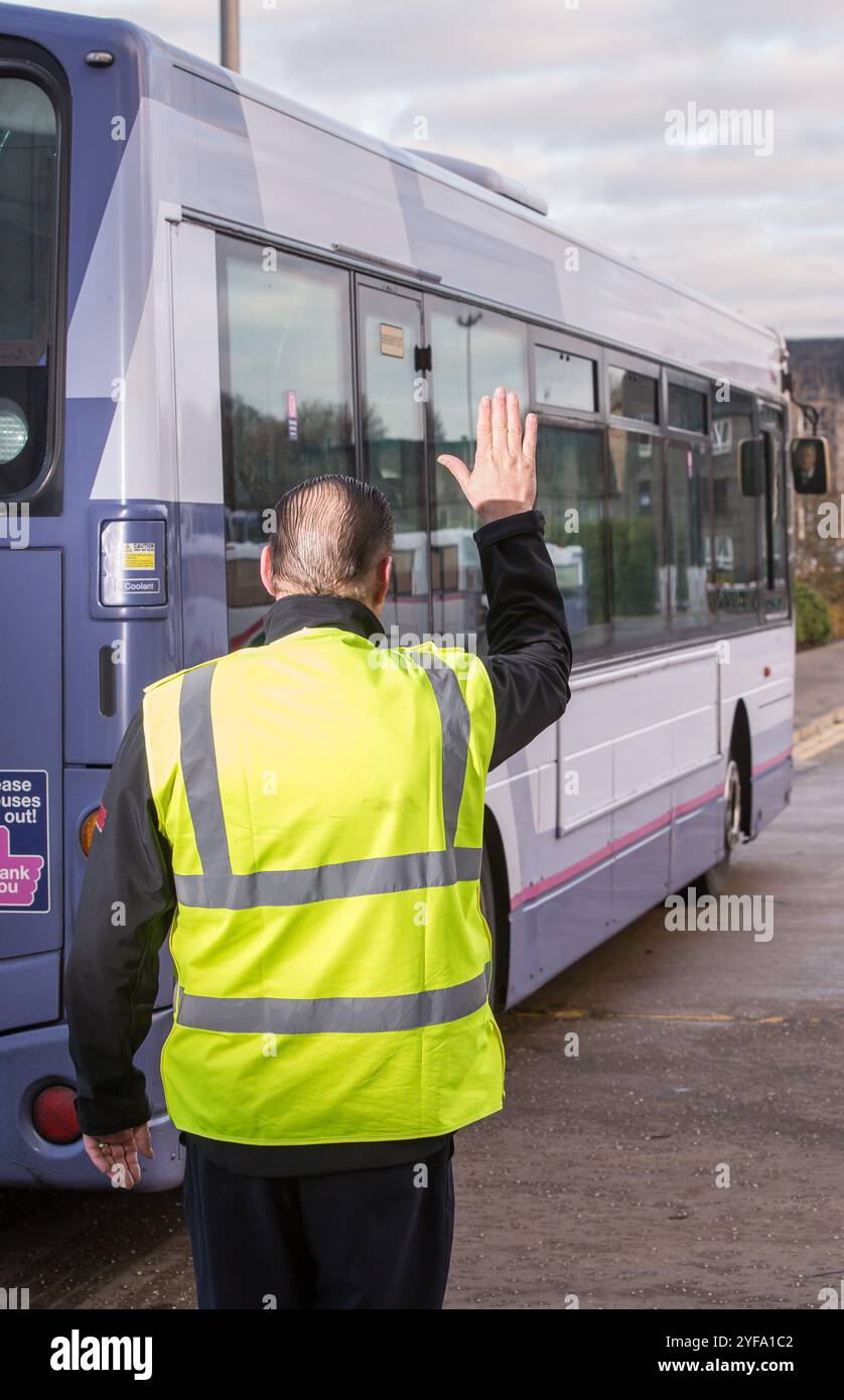 Ein Bus fährt rückwärts, während er von einem Bankmann geführt wird Stockfoto