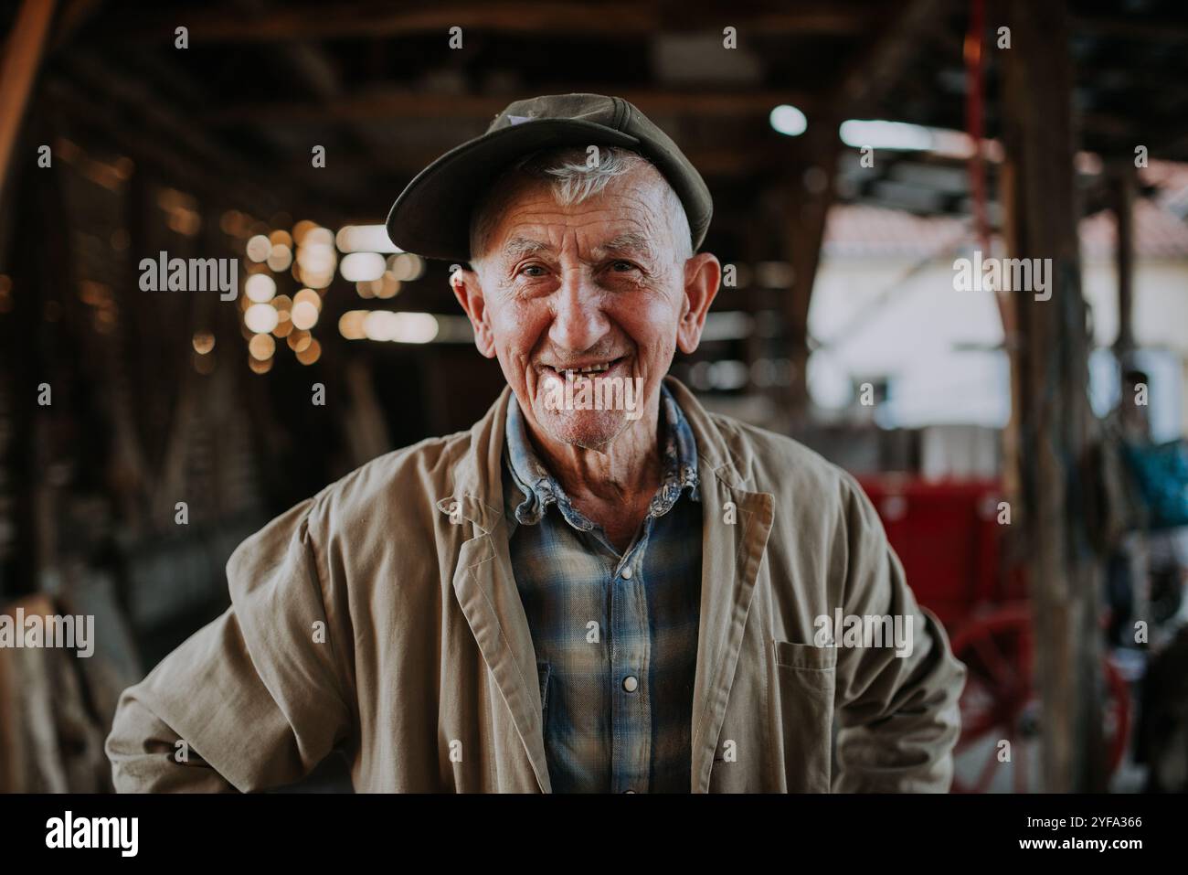 Ein alter Mann mit Hut und Trenchcoat lächelnd. Stockfoto