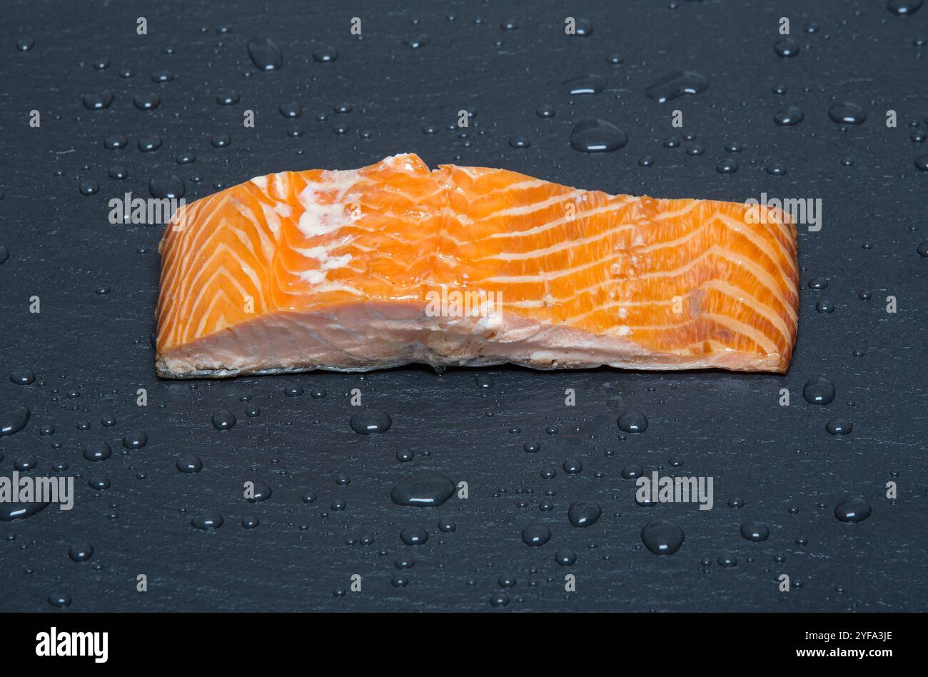 Schottisches Lachsfilet auf schwarzem Schiefer Stockfoto