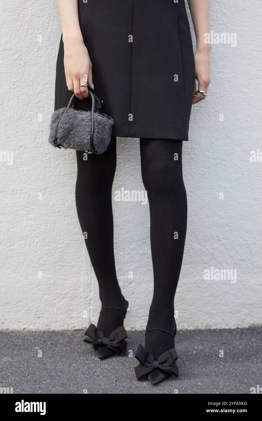 MAILAND, ITALIEN - 19. SEPTEMBER 2024: Frau mit grauer Pelztasche und schwarzen Schuhen mit Band vor der Max Mara Modenschau, Mailand Street Style Stockfoto
