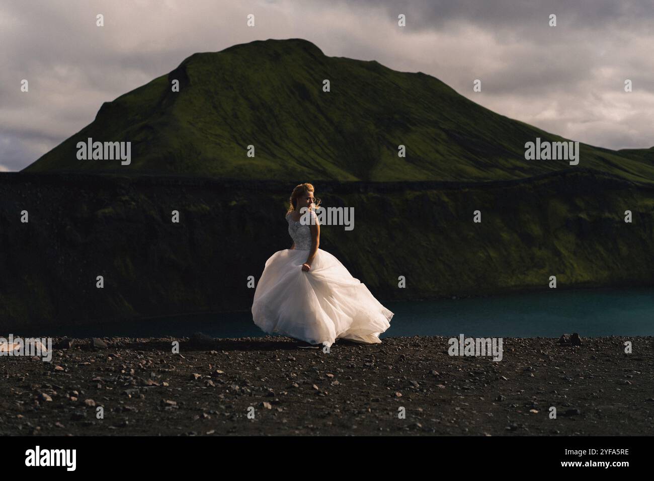 Braut im Hochzeitskleid in den Bergen Islands Stockfoto