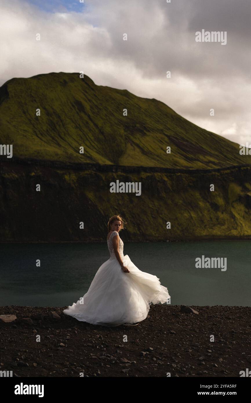 Braut im Hochzeitskleid in den Bergen Islands Stockfoto