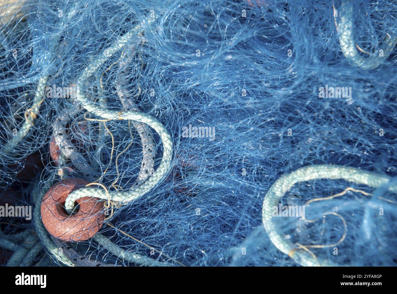 Körbe voller blauer Fischernetze auf einem Fischerboot Stockfoto