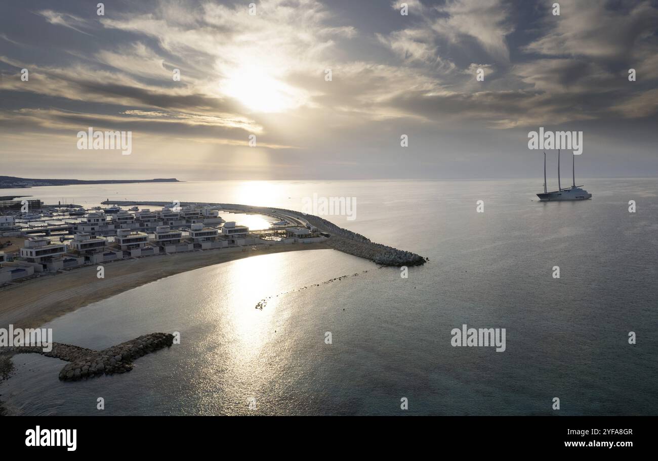Drohnenblick auf eine Luxusyacht, die bei Sonnenaufgang vor einem Hafen vertäut ist. Ayia Napa neuer Yachthafen Zypern Stockfoto