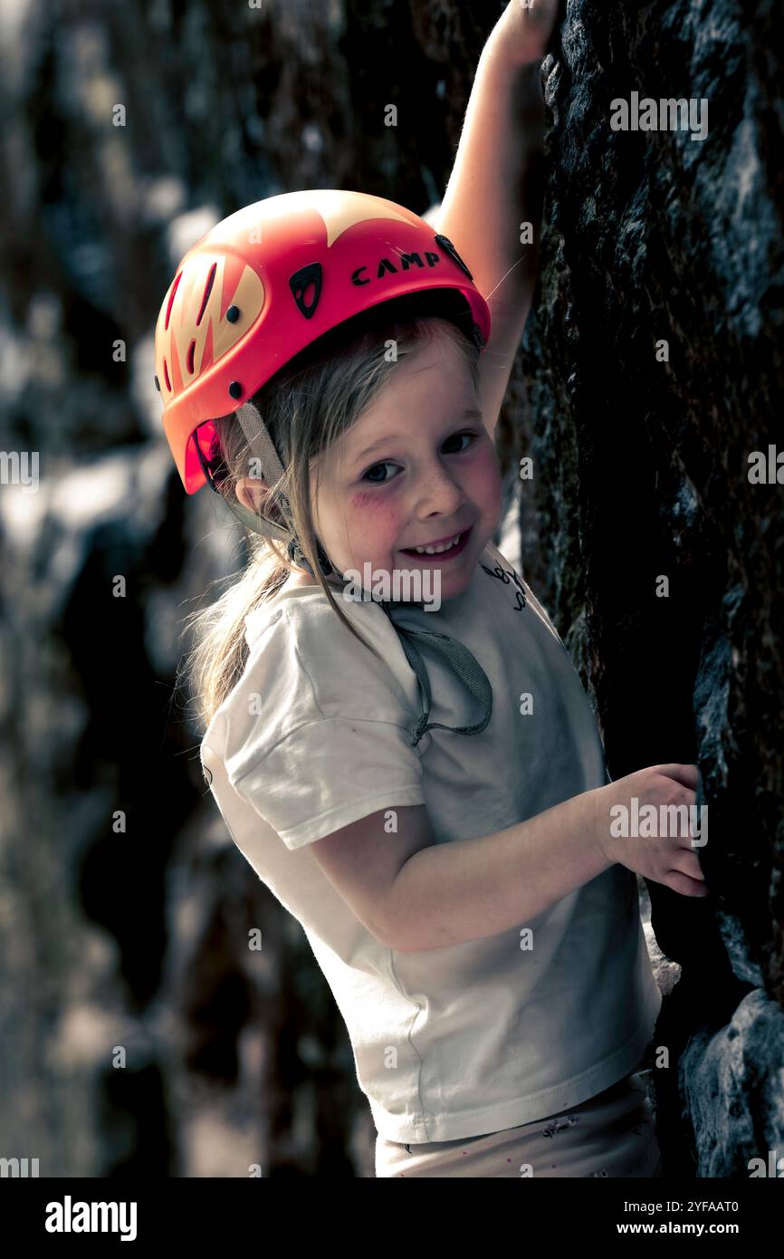 5-jähriges Mädchen klettert und Bouldern mit roten und schwarzen Kletterschuhen. Stockfoto