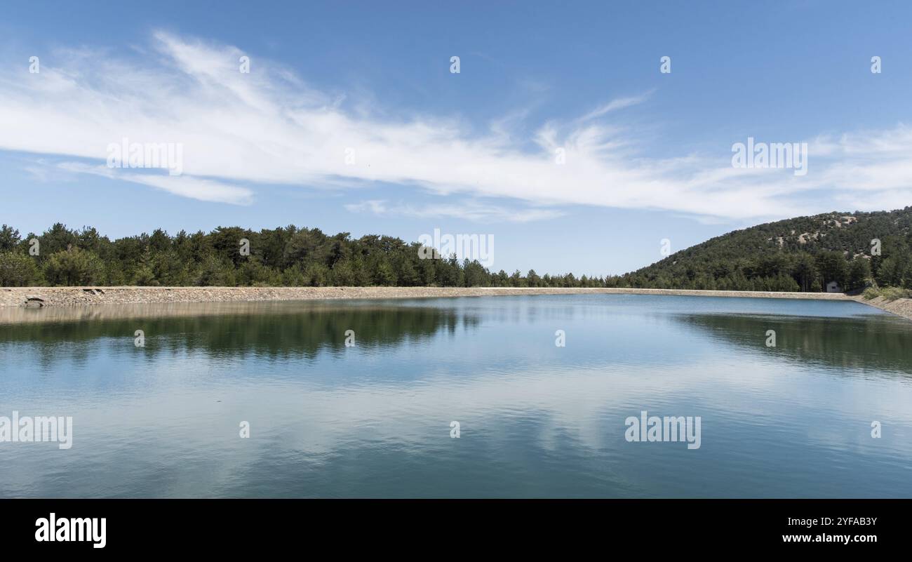 Staudamm des Wasserreservoirs mit vorderster Baumspiegelung im Dorf Prodromos im Troodos-Gebirge auf Zypern Stockfoto