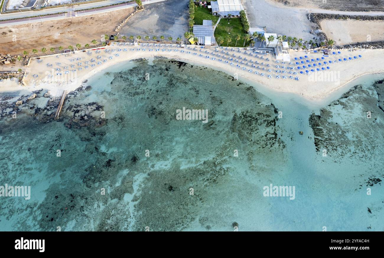 Drone-Luftaufnahme eines Ferienortes und einer Küste mit türkisfarbenem Meerwasser. Agia thekla, agia napa, zypern. Sommerferien und Urlaub im Stockfoto