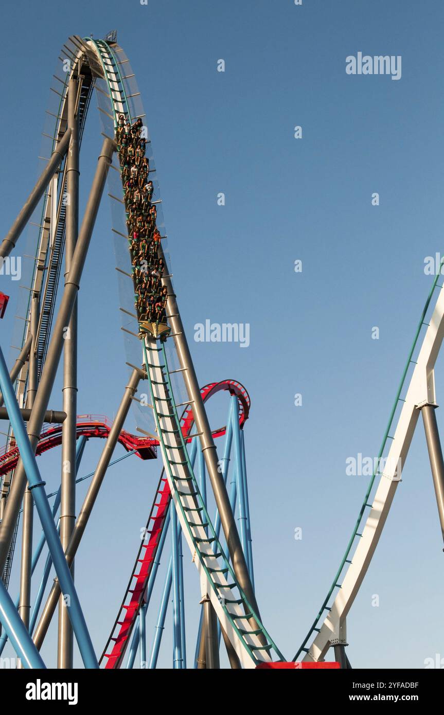 Barcelona, Spanien - 3. August 2012: Menschen auf einer extremen Achterbahnfahrt im berühmten Vergnügungspark Port Aventura vor einem blauen Himmel in Barcelona, Spanien Stockfoto