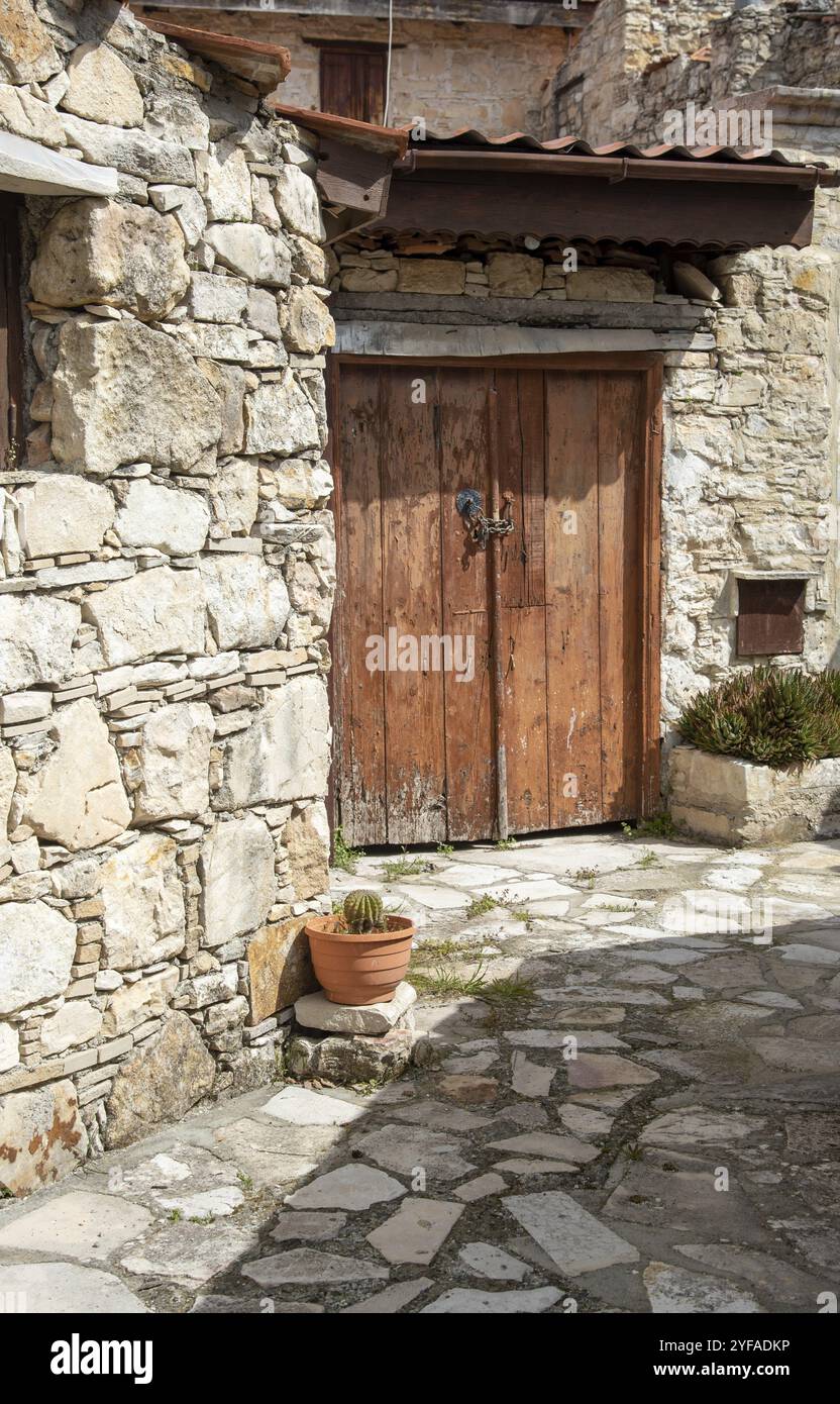 Steiniger Fußweg durch ein traditionelles Dorf. Steinige Häuser mit Holztüren. Vintage-Architektur. Dorf Lofou, Zypern, Europa Stockfoto