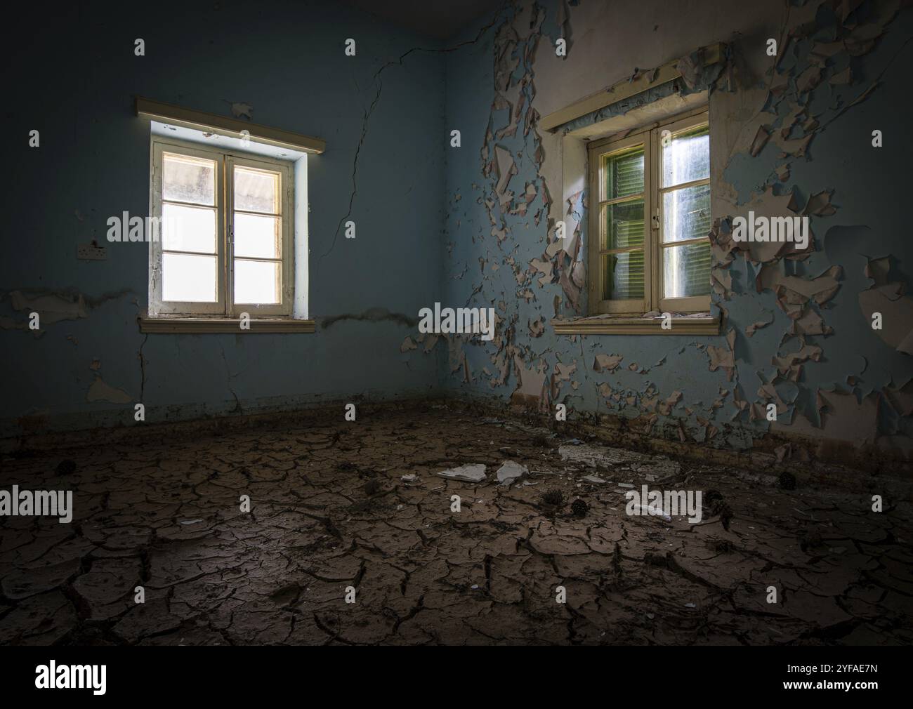Innenraum einer schmutzigen und leeren abgerissen aufgegeben mit offenem Fenster trocken und rissig Schlamm Stockfoto