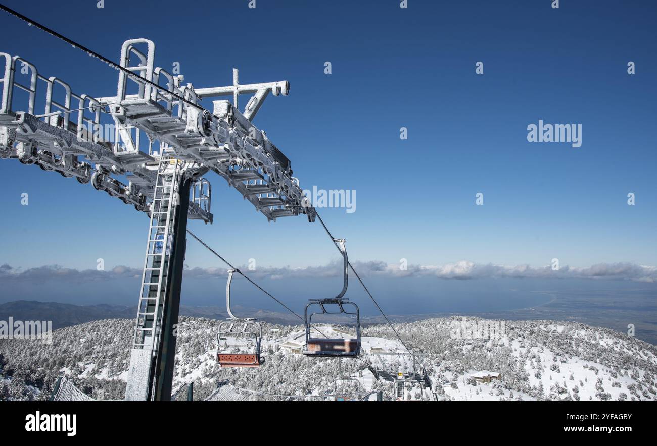 Gefrorener Skilift auf einem schneebedeckten Berg vor blauem Himmel. Troodos-Gebirge Zypern Stockfoto