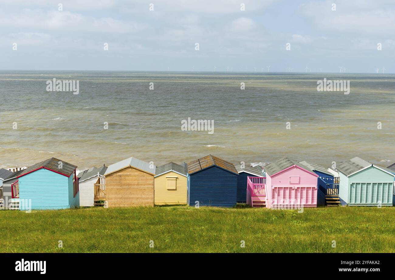 Farbenfrohe Ferienhütten mit Blick auf das ruhige blaue Meer. Whitstable, Kent Südostengland Stockfoto